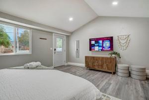 a bedroom with a large bed and a flat screen tv at Institute Charm - Near Hotspots King Sleek Studio in Colorado Springs