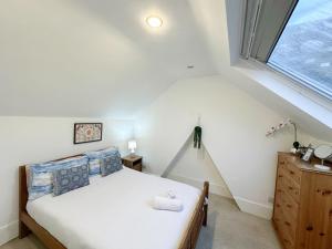 a bedroom with a bed and a window at Lovely 3 bedroom maisonette with private roof terrace in Hammersmith in London