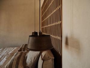 a lamp hanging from a wall next to a bed at The Wild by Interni in Kalafatis