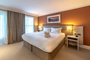 um quarto de hotel com uma cama grande com um urso de peluche em The Ro Hotel Windermere em Bowness-on-Windermere