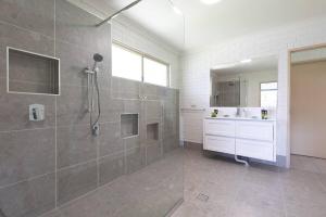 a bathroom with a shower and a sink at Bella Rose Beach House - 3 BR - 5min to Beach in Agnes Water +10 photos