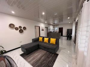 a living room with a couch and yellow pillows at Kasuba Two Bedroom Apartment in Livingstone