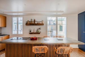 a kitchen with a large island with two chairs at Paris Trocadero Elegant Residence in Paris