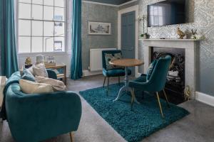 a living room with blue chairs and a fireplace at Highgate House in Whitby