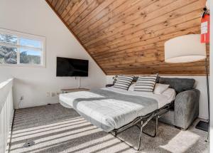 1 dormitorio con 1 cama grande y techo de madera en Lorraine Loft - Pet-Friendly Game Room Hot Tub Pit, en Woodland Park