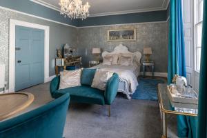 Highgate House في ويتبي: غرفة نوم بسرير واريكة زرقاء