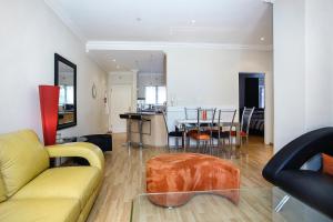 een woonkamer met een gele bank en een tafel bij The Melrose Kernick Avenue Apartment in Johannesburg