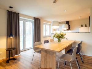 a kitchen and dining room with a wooden table and chairs at Domizil am Gohrisch in Kurort Gohrisch