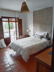 a bedroom with a large white bed and a balcony at Casa Franci in Granada