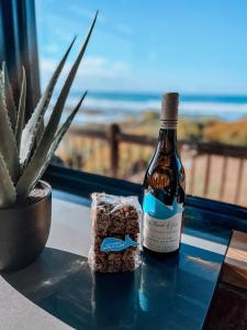 una botella de vino sentada en una mesa con un cactus en Witsand Whalecliff accommodation en Witsand