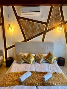 a bedroom with a bed with gold pillows at Egri Leányka Vendégház in Eger