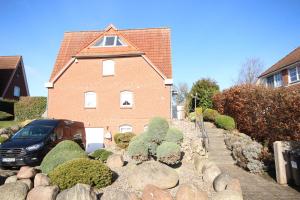 une maison avec une voiture garée devant elle dans l'établissement Haus am Fuchskamp, à Grömitz