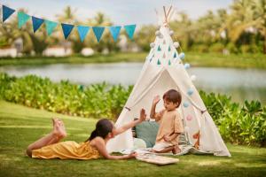 uma rapariga e um rapaz a brincar numa tenda com uma tenda de brincar em Danang Marriott Resort & Spa, Non Nuoc Beach Villas em Da Nang