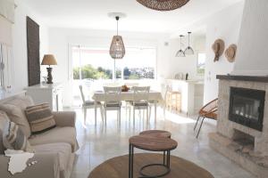 ein weißes Wohnzimmer mit einem Tisch und einem Kamin in der Unterkunft Casita Adelfa in Calpe