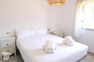ein Schlafzimmer mit einem weißen Bett und Handtüchern darauf in der Unterkunft Casita Adelfa in Calpe