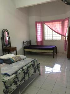 - une chambre avec 2 lits et une fenêtre dans l'établissement Addeen homestay, à Kampong Kemaman