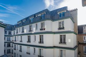 a white building with a black roof at Paris Trocadero Elegant Residence in Paris