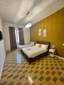 een slaapkamer met een bed en een gele muur bij San Peter Vale House in Rome