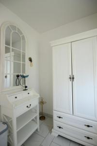 - une salle de bains blanche avec une commode blanche et un miroir dans l'établissement Haus am Fuchskamp, à Grömitz