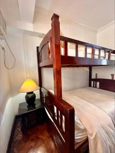 een slaapkamer met 2 stapelbedden en een lamp bij East Ortigas Mansions by MA in Manilla