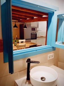baño con lavabo y cocina en La Cabaña del Risco, en Ligos