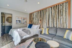 a living room with a bed and a couch at PeakView Lil Lux - Prime Spot King Hot Tub Views in Colorado Springs