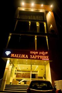 齊齊曼卡羅的住宿－The Mallika Sapphire，夜间停在大楼前的汽车