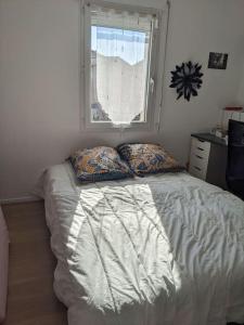 1 cama en un dormitorio con ventana en Maison familiale spacieuse proche Aix/Marseille en Vitrolles