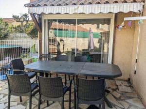 una mesa y sillas en un patio en Maison familiale spacieuse proche Aix/Marseille en Vitrolles