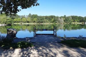 un parco con panchina di fronte a un lago di Maison familiale spacieuse proche Aix/Marseille a Vitrolles