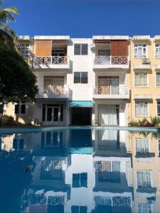 an apartment building with a pool in front of it at Le Residence Blue Bay in Blue Bay