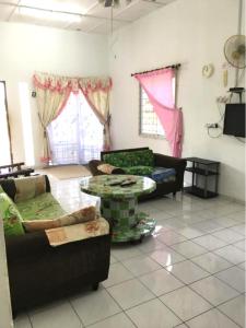- un salon avec deux canapés et une table dans l'établissement Addeen homestay, à Kampong Kemaman