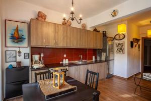 a kitchen with wooden cabinets and a dining table at The Garden Villa Hanioti in Hanioti