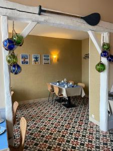 une salle à manger avec une table, des chaises et des vases dans l'établissement Hôtel De La Mer - Deauville Blonville - Boutique Hôtel de charme vue Mer ou Campagne - Accès direct plage, à Blonville-sur-Mer