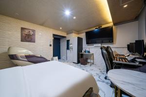 una camera d'albergo con letto, scrivania e TV di Z Hotel a Pansong