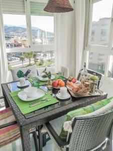 een eettafel met een dienblad met eten erop bij Studio Apartment Torrox With Sea Views in Torrox