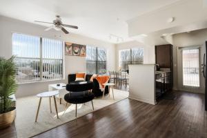 a living room with a table and chairs and a kitchen at Corporate Housing by MGM in Farmers Branch
