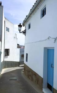 un edificio bianco con una porta blu su una strada di Casa Saucejo a El Saucejo