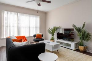 a living room with a couch and a tv at Stylish 1BR Farmers Branch in Farmers Branch