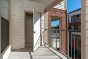 a balcony with a white door and a brick building at Stylish 1BR Farmers Branch in Farmers Branch