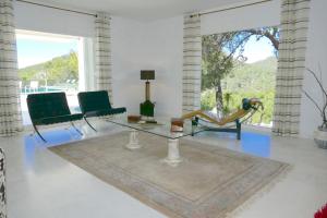 Villa Dream - Santa Eulalia في كالا يونغا: غرفة معيشة مع طاولة وكراسي زجاجية