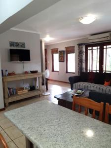 a living room with a couch and a table at Gecko Cottages in Hectorspruit