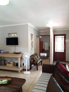 a living room with a couch and a tv at Gecko Cottages in Hectorspruit