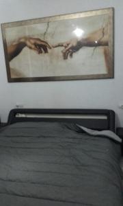 obraz na ścianie nad łóżkiem w sypialni w obiekcie Habitacion privada en un dúplex w Sewilli