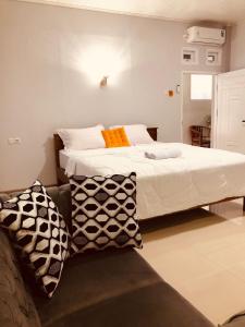 una camera con un grande letto e un divano di La Geiro Villa Labuan Bajo a Labuan Bajo