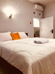 1 cama blanca grande con 2 almohadas en La Geiro Villa Labuan Bajo, en Labuan Bajo