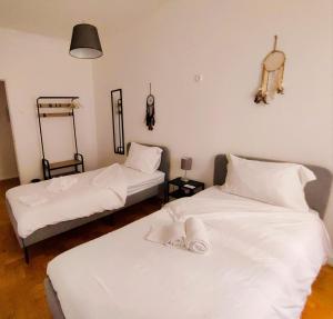 two beds in a room with white sheets at Casas da Biquinha in Sintra