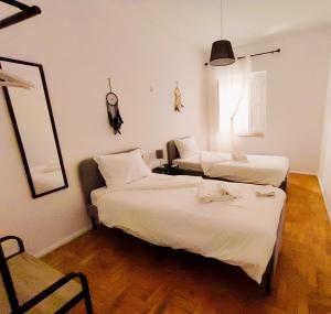 a hotel room with two beds and a chair at Casas da Biquinha in Sintra