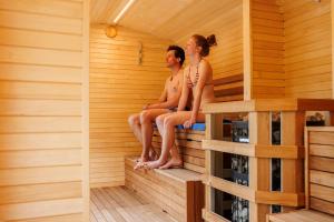 Due persone sono sedute in una sauna di Camping Zoo ad Arco