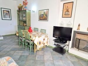 salon ze stołem, krzesłami i telewizorem w obiekcie La Terrazza w mieście Villasimius